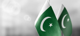 Fototapeta  - Small national flags of the Pakistan on a light blurry background