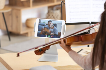 Wall Mural - Little girl taking music lessons online at home