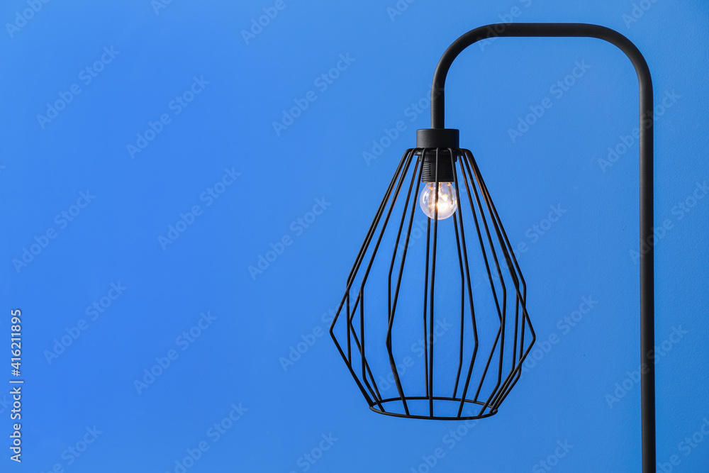 Stylish lamp on color background