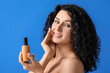 © Pixel-Shot - Beautiful young woman with cosmetic product on color background