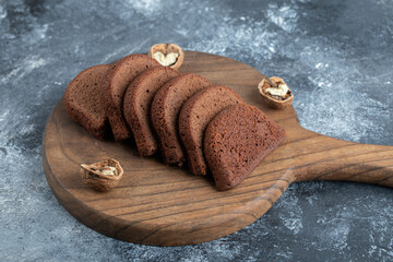 Wall Mural - A wooden cutting board with slices of bread and walnuts