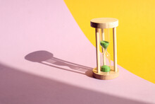 Hourglass On A Yellow-purple Background With Its Own Shadow, Side View-the Concept Of The Transience Of Time