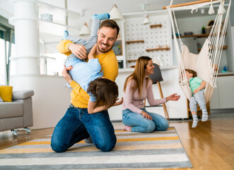 Poster - Happy young family having fun and being playful at home