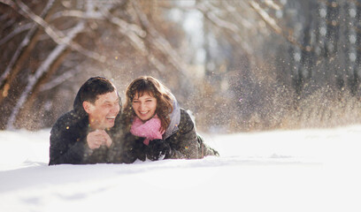 Happy couple lying on the snow and laughing