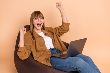 Poster - Photo of blond hooray lady sit on bag yell laptop wear spectacles shirt jeans sneakers isolated on beige color background