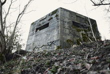 A Brutalist Cold Gritty Concrete World War Two, Ww2, Pillbox War Bunker Defence Fortress In A Dirty Forgotten Woodland In Europe. Wartime Relics And Forgotten Outpost Using Solid Architecture
