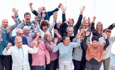 group of elderly friends raised their hands up and celebrate suc