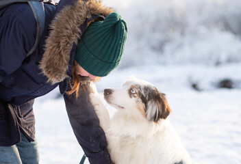  australian shepherd dog touching its owner woman with paw 