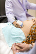 Pregnant woman getting ultrasound from doctor. Doctor screening of pregnant woman by ultrasound. Doctor makes the patient women abdominal ultrasound.