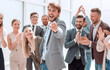 © ASDF - happy business man standing among colleagues and pointing at you.