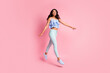 © deagreez - Full size photo of optimistic brunette lady go jump wear blue top trousers sneakers isolated on pink color background