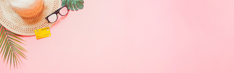 summer accessories concept from credit card and summer collection on pastel red background. web banner size.