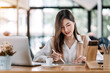 © amnaj - Beautiful Asian business woman working at the office With tablet.