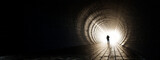 Fototapeta Perspektywa 3d - Concept or conceptual dark tunnel with a bright light at the end or exit as metaphor to success, faith, future or hope, a black silhouette of walking man to new opportunity or freedom 3d illustration