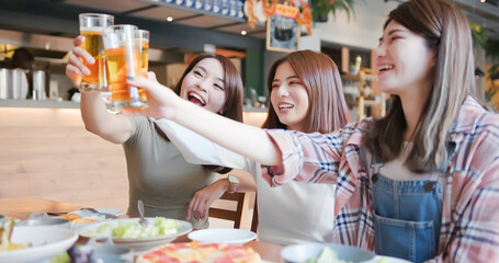 friends toast beer in restaurant