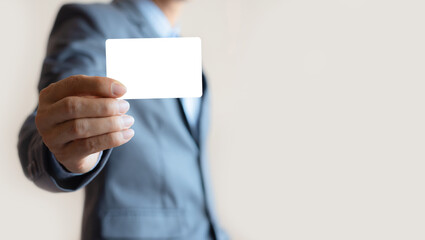 close up attractive business man holding blank white mock up card in hand.