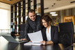 © bnenin - Portrait of a two business executives looking at report with good business results.