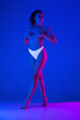 © master1305 - Glowing. Beautiful female body on blue background in neon light. Beauty, cosmetics, spa, depilation, diet and treatment, fitness concept. Fit and sportive, sensual body with well-kept skin.