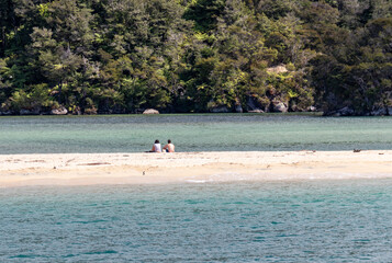 Sticker - Couple sur un banc de sable du parc Abel Tasman, Nouvelle Zélande