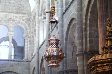 botafumeiro of the cathedral of santiago de compostela hung with rope and in the background you can see stone arches with large windows