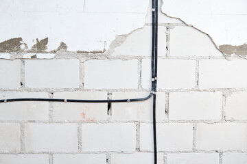 Electrical wires on brick wall. Cable laying