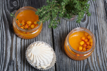 Wall Mural - Sea buckthorn jelly. Decorated with sea buckthorn berries and thyme. Nearby is sea buckthorn marshmallow.