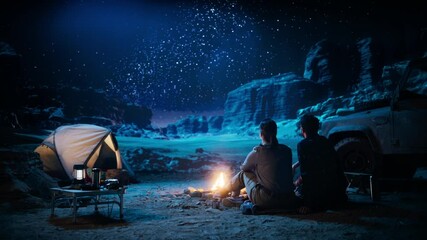 Wall Mural - Happy Couple Tent Camping in the Canyon, Sitting by Campfire Watching Night Sky with Milky Way Full of Bright Stars. Two Travelers In Love On a Romantic Vacation Trip. Zoom Out Back View Shot