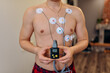 Heart electrocardiogram or monitoring using Holter for young patient. Male athlete does a cardiac stress test. wearing Holter monitor device for daily monitoring of an electrocardiogram. 