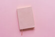 High angle closeup view of blank pink journal on pastel background