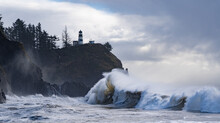 Huige Waves Crashing On The Headland Under Cape Disapointment Lighthouse Near The Mouth Of The Columbia River, Ilwaco, Washington