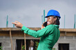 © kehinde - A Nigerian female construction and architectural engineer with blue safety helmet happily talking on cell phone