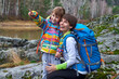 © Joe-L - Travel family - mother and child with backpacks laugh and point with their finger to distance