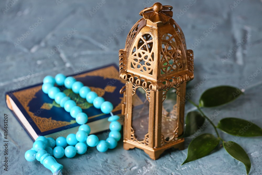 Muslim lamp, tasbih and Koran on color background