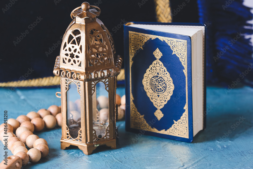Muslim lamp, tasbih and Koran on color background