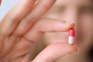 Poster - Beautiful young woman with pill, closeup