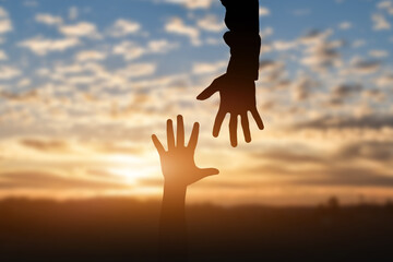 Fototapete - Silhouette of reaching, giving a helping hand, hope and support each other over sunset background. Help concept