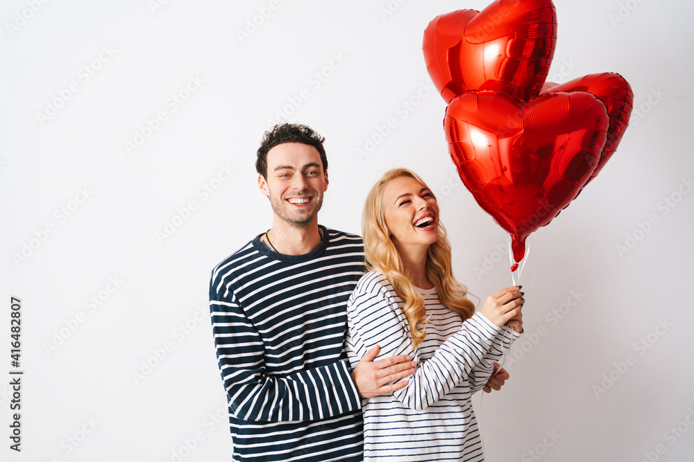 Happy romantic couple laughing while posing with heart balloons Stock ...