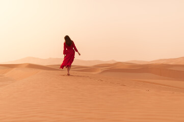 A girl in a red dress in the desert