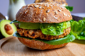 Tasty vegetarian healthy food, homemade burgers made from orange lentils legumes with green lettuce and fresh ripe avocado