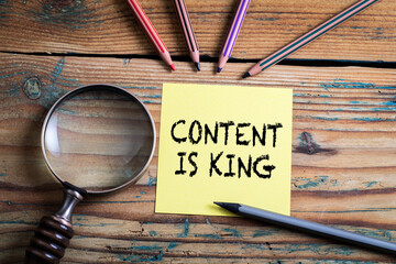 Wall Mural - content is king. magnifying glass and pencils on a wooden table
