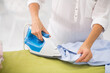 © zinkevych - Woman in white shirt looking busy while ironing clothes