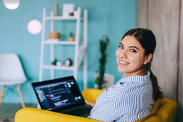 portrait of young woman mobile developer with laptop, writes program code on a computer, programmer 