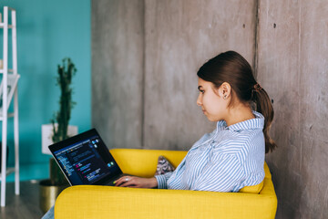 young woman mobile developer with laptop, writes program code on a computer, programmer work in mode