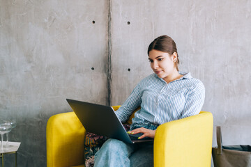 Young woman mobile developer with laptop, writes program code on a computer, programmer work in modern office.