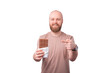 cheerful handsome man with beard pointing at block of chocolate standing over white background