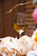 Close up photo of glass of white wine over flower background
