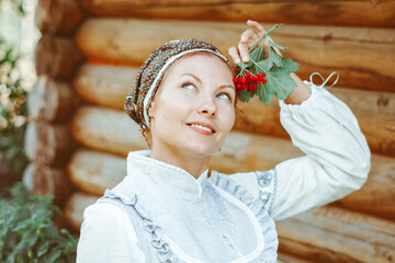 beautiful girl in an old dress near a wooden house