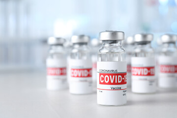 Wall Mural - Glass vials with COVID-19 vaccine on light table. Space for text