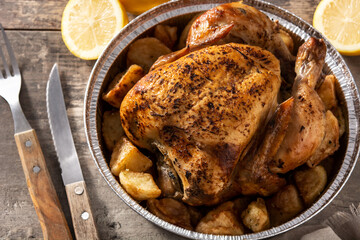 Delivery roasted chicken with potatoes on wooden table