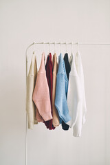 multicolored women's woolen sweaters on hangers. Sale in a fashion store